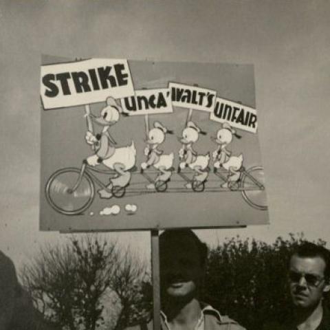 A protester with a sign that reads, "Strike, unca’ Walt's unfair"