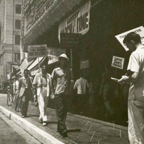 Protesters outside of a theater, urging people not to buy tickets