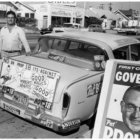Campaign associate in front of the "No on Proposition 18" campaign car, 1958