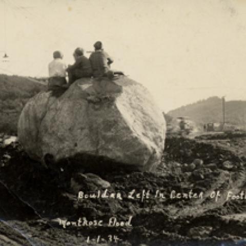 Boys sitting on top of a boulder after the Montrose flood, 1934