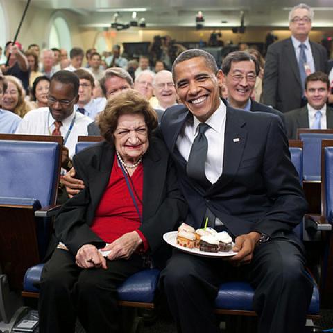 President Barack Obama presents cupcakes with a candle to Hearst White House columnist Helen Thomas in honor of her birthday in the James Brady Briefing Room, on Aug. 4, 2009