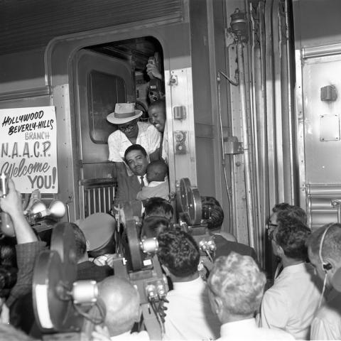 The Civil Rights activist Celes King III exits a train with a displaced Louisiana family arriving in LA, 1962. Harry Adams Collection. The Civil Rights activist Celes King III exits a train with a displaced Louisiana family arriving in LA, 1962. Harry Adams Collection.
