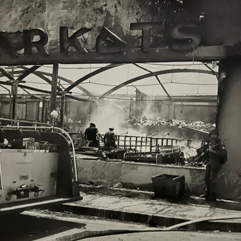 A National Guard member and the back end of a fire truck in front of a supermarket that burned down in Watts, 1965, League of Women Voters of Los Angeles Collection. 