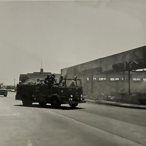 A fire truck that includes National Guard members in front of a supermarket that burned down in Watts, 1965, League of Women Voters of Los Angeles Collection. 