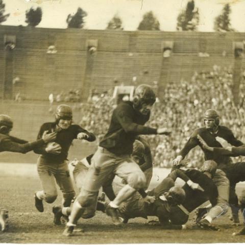 Scrapbook page photograph of Occidental College football players in action, ca. 1920s