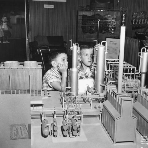 Two Children looking at a model in the American Pipe and Steel booth at the 1955 Union Products and Services Show