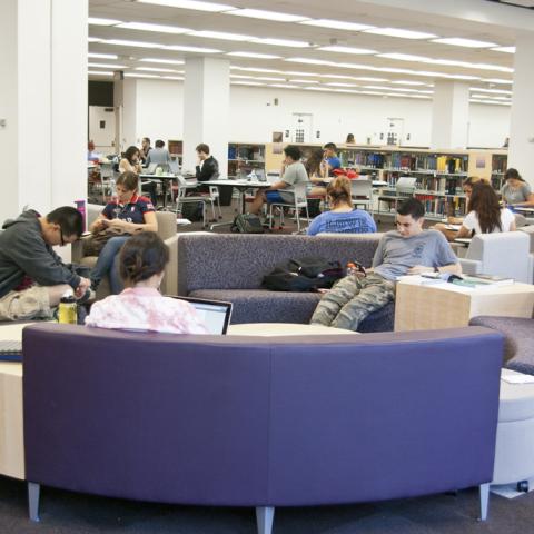 Wide shot of the learning commons core, laptop bars, new reference stacks, and lobby.