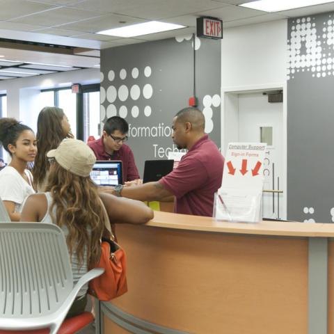 IT Help Desk workers helping students with technology.