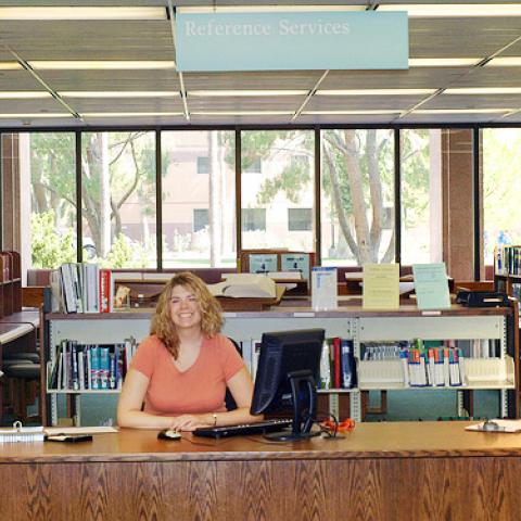 Librarian seated at the old reference desk.