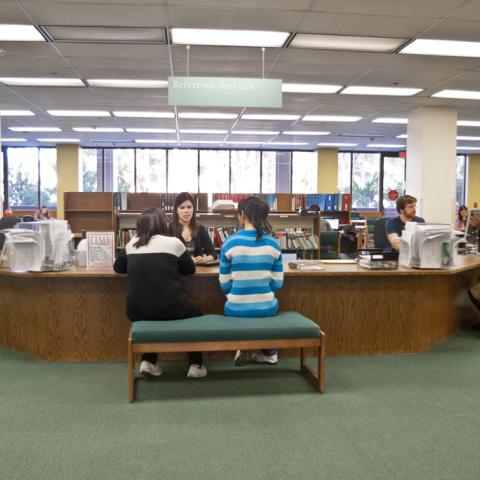 Students getting research help at the old reference desk.
