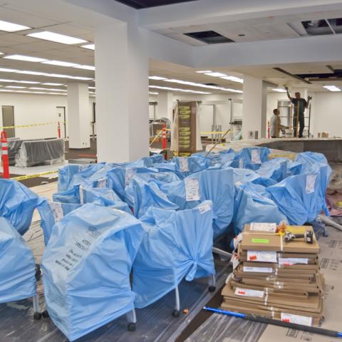Work being done on the new reference desk, and new furniture waiting to be unpacked.