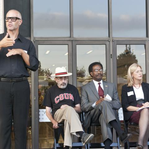Provost & Vice President for Academic Affairs Harry Hellenbrand, Vice President for Student Affairs William Watkins and CSUN President Dianne Harrison listen to Dean Stover's speech, while an ASL interpreter translates.