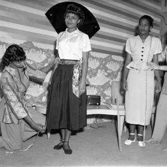 Tailors taking measurements of women