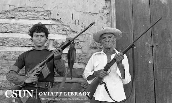 An elderly man and a young man both brandishing rifles