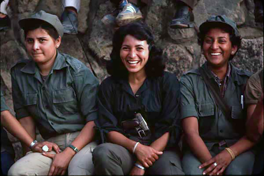 People and soldiers holding guns outside a home