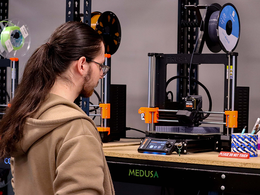 Person looking at a working 3D printer.