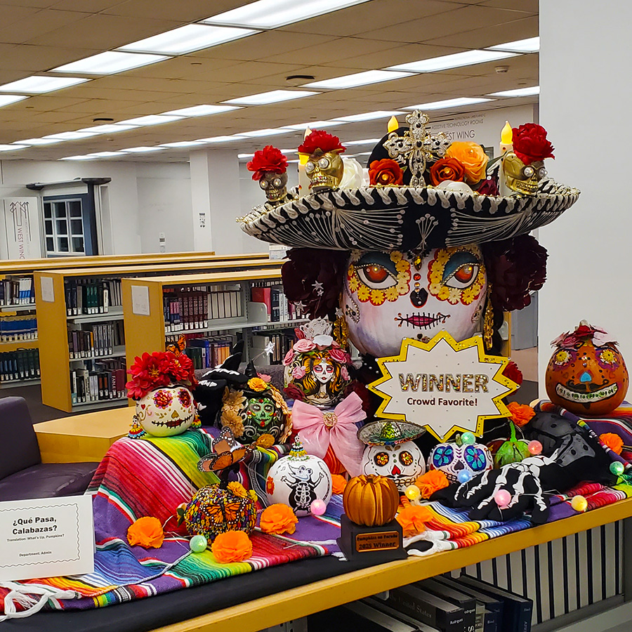 Pumpkin styled in Dia de los Muertos with smaller pumpkins around it.