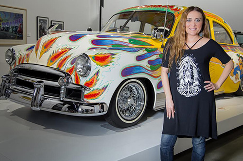 Denis Sandoval in front of a lowrider car