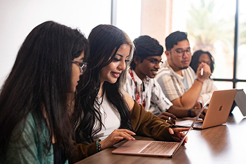 students at a study table near a window