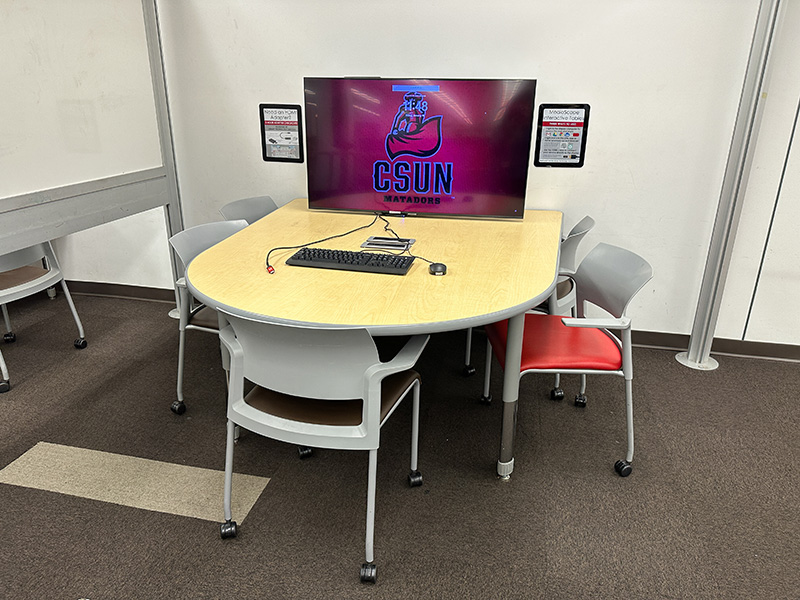 A study table with a large monitor on the table.
