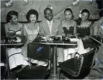 Lorraine Adams (left), Elihu “Black Dot” McGee (center) and his wife Elizabeth (right of McGee), and others at the Tiffany Club