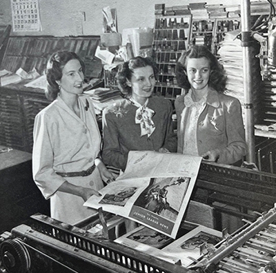 Members holding a freshly printed issue of the Los Angeles Junior League news