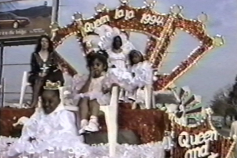 Children and the Queen of LALA 1994 dressed in white gowns sitting atop a red and gold float. Harold Hambrick Collection. 