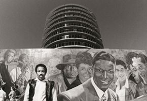 Artist Richard Wyatt, Jr with his mural Hollywood Jazz: 1945-1972 at the Capitol Records building, 1990, Roland Charles Collection