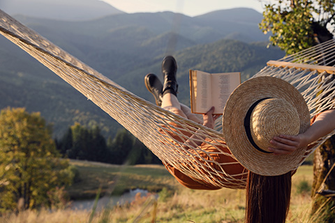 Woman reading a book in a hammock