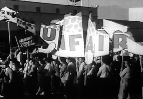 Protesters hold large sign that reads, unfair