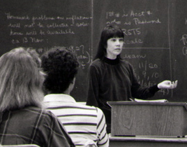 Woman giving lecture in front of chalkboard