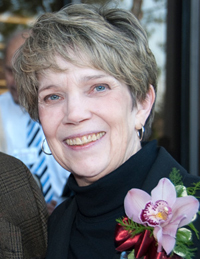 Face of Bonnie J. Campbell wearing a flower on left side of her suit