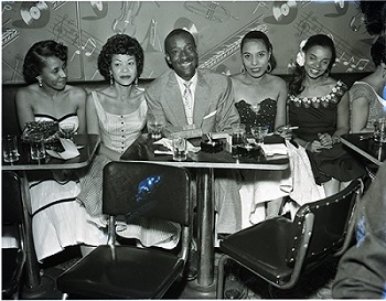 Lorraine Adams (left), Elihu “Black Dot” McGee (center) and his wife Elizabeth (right of McGee), and others at the Tiffany Club. Harry Adams Collection. 93.01.HA.B4.N45.607