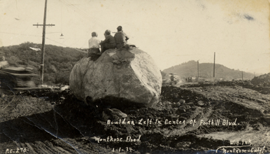 Boys sitting on top of a boulder after the Montrose flood, 1934