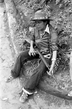 Woman Sandinista seated on a curb, Nicaragua, 1979