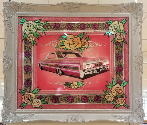 Decorative frame with engravings and flowers with a pink lowrider car