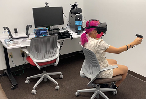 Student using virtual reality in a room with a computer on a desk