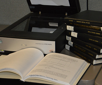 Scanning station and bound theses used as part of the Electronic Thesis and Dissertation Digitization Project.