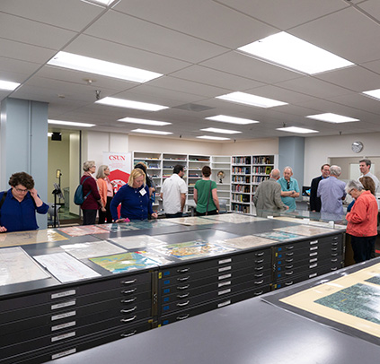 People browsing maps and materials at the Grand Opening of the Map Collection