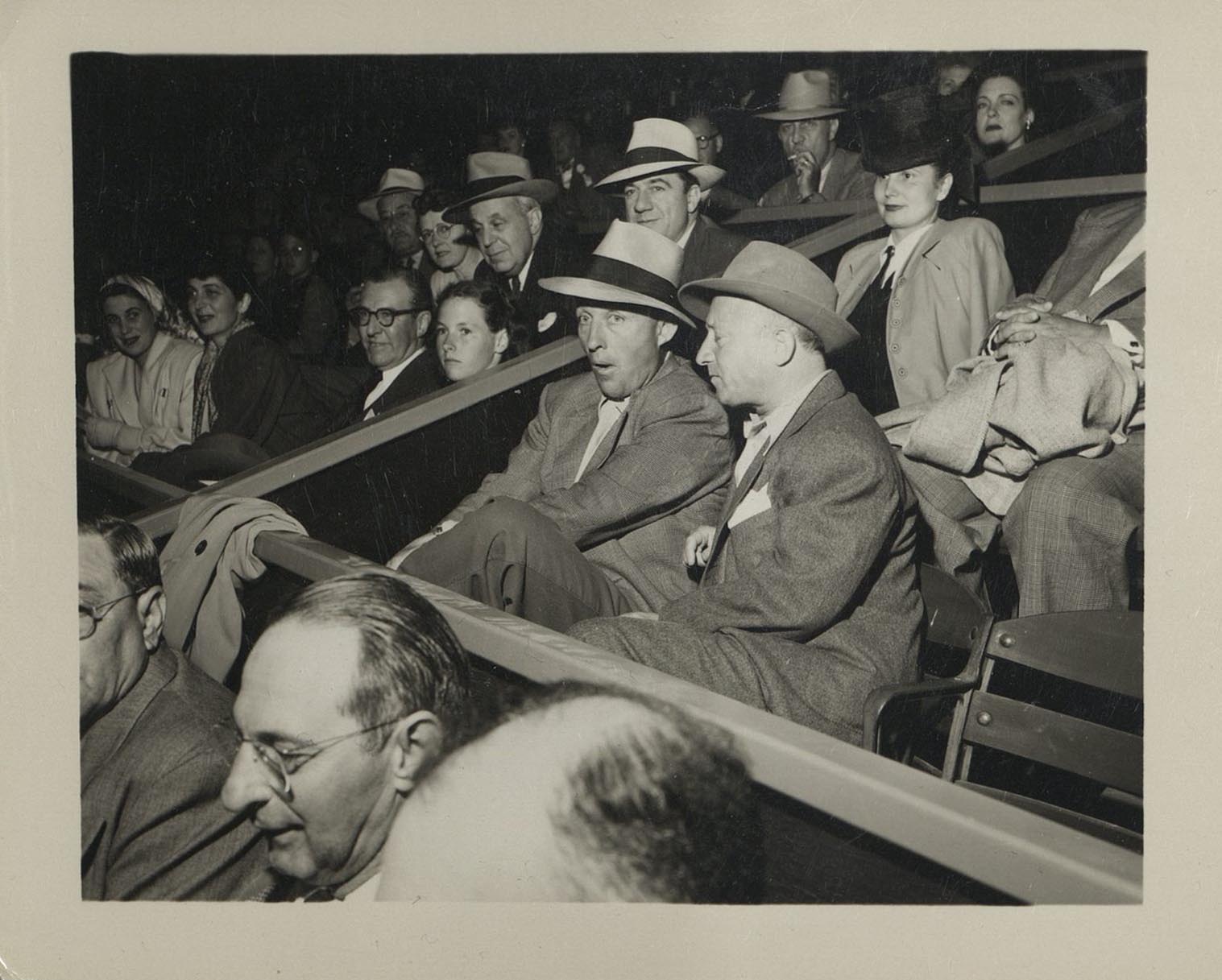 Bing Crosby in box seats surrounded by people
