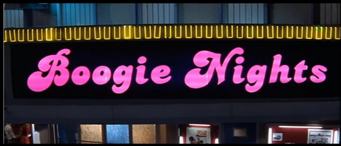Shot of the outside of a theater with sign that says Boogie Nights.