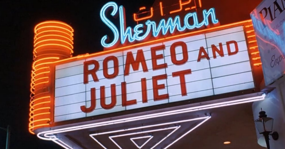 Outside of a movie theater called the Sherman with a sign that says Romeo and Juliet
